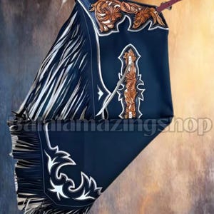 Peut inclure: Chaps en cuir bleu foncé avec des motifs floraux et géométriques complexes en marron. Les chaps présentent de longues franges blanches sur les côtés et des coutures blanches décoratives. Une sangle en cuir marron est visible en haut.