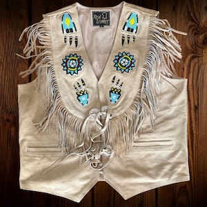 May include: A beige suede vest with fringe and beaded designs. The vest has a lace-up front and features a label that reads "Real Leather".