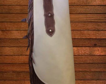 Può includere: Chaps in pelle color crema con dettagli in pelle marrone e frange. I chaps presentano cuciture decorative e rivetti, con un bordo smerlato nella parte superiore. Un classico capo western.