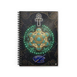 May include: Spiral-bound notebook with a detailed cover design. The cover features a central geometric pattern with teal accents, surrounded by an ankh symbol and circular text. A blue artist's palette and pen are at the bottom. The background is dark with gold accents.