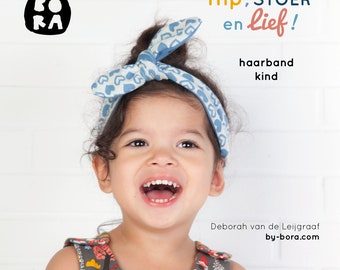 May include: A young girl wearing a blue headband with white hearts on it. The headband is tied in a bow on top of her head. She is wearing a gray dress with a colorful pattern of animals and trees. The text "Hip, STOER en lief!" is written in orange and yellow letters. The text "haarband kind" is written in black letters. The text "Deborah van de Leijgraaf by-bora.com" is written in black letters.