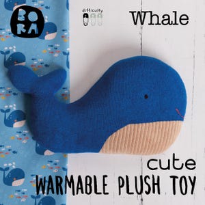 May include: A blue whale-shaped plush toy with a beige belly and a small red mouth. The text "Whale" and "cute WARMABLE PLUSH TOY" are displayed. A blue fabric with whale and fish patterns is on the left.