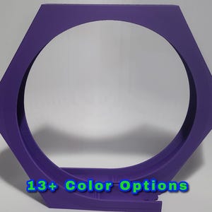 May include: A purple, hexagonal-shaped object with a circular opening in the center. The object has a flat base and the text "13+ Color Options" in blue and green. The object is likely a decorative or functional item.