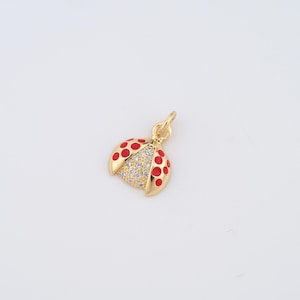 May include: Gold-tone charm in the shape of a ladybug with red enamel and clear rhinestones.