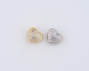 May include: Two heart-shaped charms, one gold and one silver, both covered in clear sparkling rhinestones.