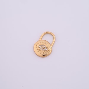 May include: Gold charm with a round evil eye design with clear rhinestones. The charm has a loop at the top for attaching to a necklace or bracelet.