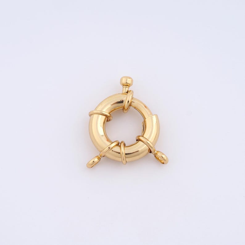 May include: Gold-toned metal clasp with a round ring and three loops. The clasp is designed to be used as a jewelry closure.