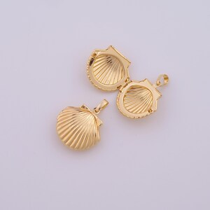 May include: Two gold-tone seashell-shaped locket pendants. One pendant is open, revealing the inside of the locket. The other pendant is closed.
