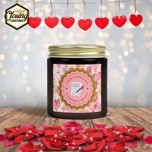 May include: A dark glass jar with a gold lid and a label that reads "Forget Chocolates, Give Me a Contract!" with a pink and gold design. Red rose petals are scattered at the base, and red heart decorations hang above.