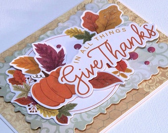 3D Thanksgiving Card Features In All Things Give Thanks Shaped Phrase, Die-Cut Fall Wreath, Multi-Colored Fall Leaves, and Pumpkin