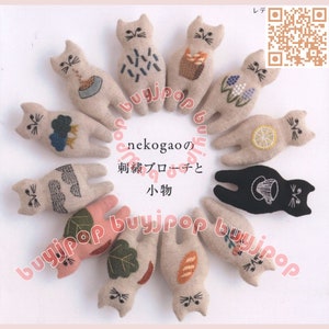 May include: A collection of 12 handmade felt cat brooches with various embroidered designs, including a lemon, a cup of tea, a loaf of bread, and a cloud. The brooches are arranged in a circle on a white background. The text "nekogao no" and "刺繍ブローチと小物" is visible in the center of the circle.
