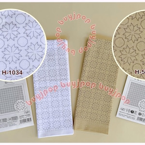 May include: Two decorative towels with a repeating star and octagon pattern. One towel is white with gray accents, the other is tan with brown accents. Each towel has a corresponding product card with the code "H-1034" and "H-5034".