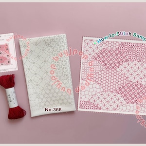 Könnte beinhalten: Japanische Stickzubehör, darunter eine rote Garnrolle, ein Stoffstück mit Muster und Stichprobenkarten. Stoff und Karten zeigen geometrische Muster in Weiß und Rot. Der Text "How-to-Stitch Sample" ist sichtbar. Maße in cm.