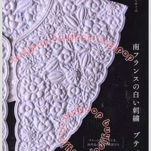 May include: A white quilted collar featuring intricate floral embroidery and a scalloped edge. The fabric displays a raised, padded texture with detailed stitching of various flower shapes and leaves throughout the entire surface.