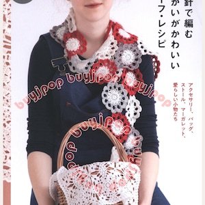 May include: A woman wearing a crocheted scarf with red, white, and gray floral designs. She is holding a wicker basket with a white crocheted cover. The image is from a Japanese book about crochet.