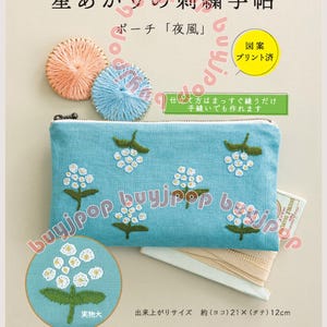 May include: A teal embroidered pouch with white floral designs, accompanied by embroidery floss and a small round embroidery. The text on the pouch reads "Star Light Embroidery Notebook". The finished size is approximately 8.25 x 4.75 inches.