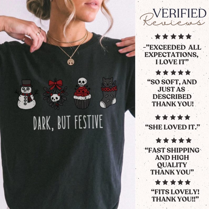 Op de afbeelding: Een zwart t-shirt met een afbeelding van een sneeuwpop, maretak met een schedel, een cupcake met een schedel en een kat in een kerstsok. De tekst luidt "DARK, BUT FESTIVE". De afbeelding bevat de kleuren zwart, wit en rood.