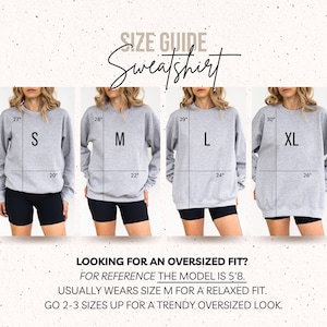 Op de afbeelding: Een maattabel voor een grijs sweatshirt met vier modellen in de maten S, M, L en XL. Elk sweatshirt toont lengte- en breedtematen in inches. De tekst bevat SIZE GUIDE, Sweatshirt en advies voor een oversized pasvorm.