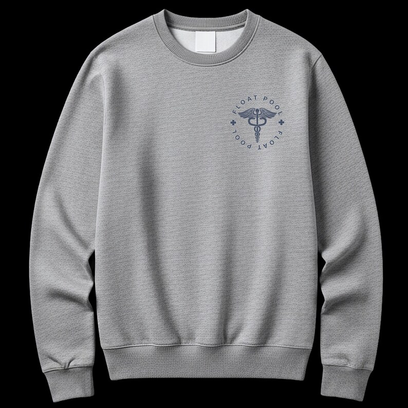 May include: A heather gray crewneck sweatshirt featuring a dark blue circular graphic on the upper left chest. The design includes a caduceus symbol in the center, surrounded by the text FLOAT POOL and two small cross icons on the sides.