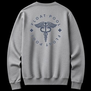 May include: A heather gray crewneck sweatshirt featuring a dark blue graphic on the back. The design includes a central caduceus symbol enclosed in a circle with the text FLOAT POOL repeated around the perimeter and two small plus signs.