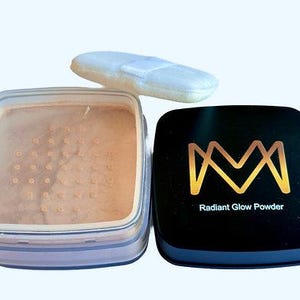 K&ouml;nnte beinhalten: Offener Kompaktpuder von Radiant Glow Powder mit hellem Beige, einem wei&szlig;en Puderquaste und einem schwarzen Kompaktdosendeckel mit goldenem "M"-Logo und den Worten "Radiant Glow Powder". Der Kompaktpuder ist ge&ouml;ffnet und zeigt das Puder.