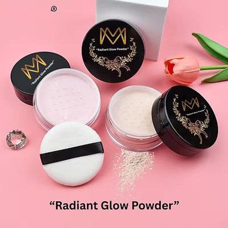 K&ouml;nnte beinhalten: Eine Auswahl an Radiant Glow Powder Make-up-Produkten. Das Bild zeigt Gl&auml;ser mit schwarzen Deckeln und dem Markenlogo, offene Gl&auml;ser mit rosa und beigem Puder und ein wei&szlig;es Puderquaste mit schwarzem Band. Der Text "Radiant Glow Powder" steht unten.