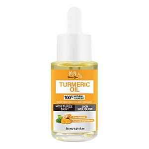 Golden turmeric facial oil in a clear glass dropper bottle. This natural skin brightening serum is designed for a glowing complexion and targeted scar reduction on the face and body.