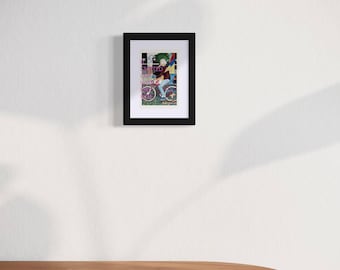 Peut inclure: Une impression encadrée d'une illustration colorée représentant une personne à vélo. L'illustration est sur fond de bâtiments et d'arbres. Le texte "Édition limitée" est visible sur l'image.
