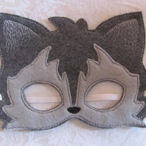 May include: Gray felt wolf mask with white felt ears and eyes. The mask has an elastic band for wearing.