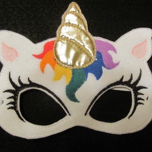 May include: White felt unicorn mask with a rainbow mane and a gold horn. The mask has black eye holes and elastic straps.