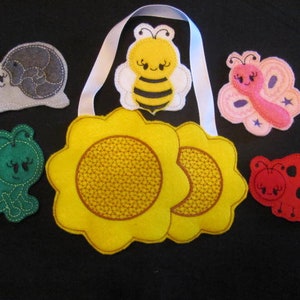May include: A set of felt appliques featuring a bee, butterfly, ladybug, snail, and two sunflowers. The appliques are colorful and have embroidered details.
