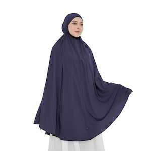 Può includere: Un indumento da preghiera in tinta unita blu navy scuro caratterizzato da un copricapo aderente che si trasforma in una silhouette ampia e fluida a mantella a figura intera. Il tessuto è opaco e cade uniformemente attorno al corpo.
