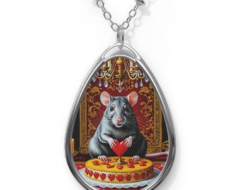 May include: A silver necklace with a teardrop-shaped pendant featuring a black rat holding a red heart in front of a red and gold throne. The rat is sitting on a cake with red hearts.