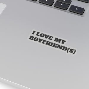 May include: A silver laptop with a black keyboard and a white touchpad. A sticker on the laptop reads "I LOVE MY BOYFRIEND(S)" in black text.