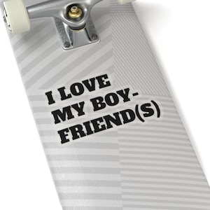 Op de afbeelding: Een skateboard deck met een grijs en wit geometrisch patroon. De tekst "I LOVE MY BOYFRIEND(S)" is gedrukt in vette zwarte letters op een witte sticker. De skateboard truck is zilver.