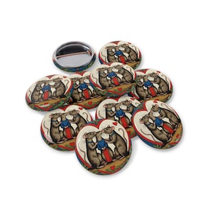 May include: A set of eight 1.25 inch button pins featuring a vintage illustration of two rats kissing inside a heart. The rats are wearing blue and red clothing and are surrounded by a red and green floral design.