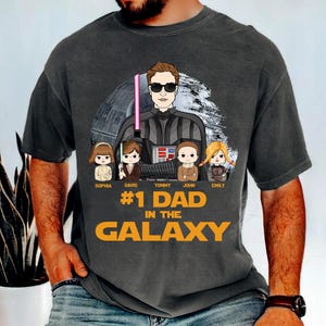 1 Dad in the Galaxy Shirt, Custom Father’s Day Gift, Personalized Star Hero Dad Tee, Funny Shirt for Dads with Kids Name, Funny Dad Shirt