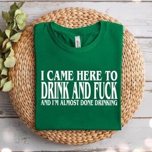 a green t - shirt that says i came here to drink and fuck and i