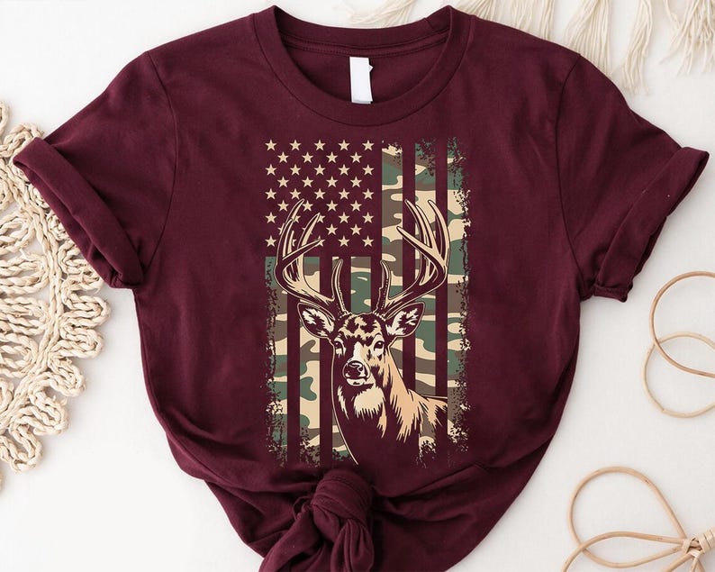 A burgundy t-shirt with a graphic design featuring a deer's head and an American flag pattern.