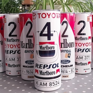May include: White cylindrical tumblers with red and black graphics. The tumblers feature the Marlboro logo, racing numbers, and sponsor logos like Toyota, Repsol, and Michelin. The design includes the text "KAM 8524".