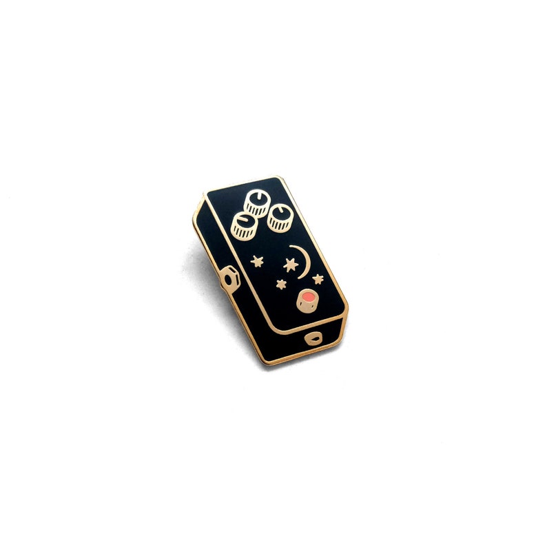 May include: Black and gold guitar pedal with three knobs and a red button. The pedal has a crescent moon and stars design.