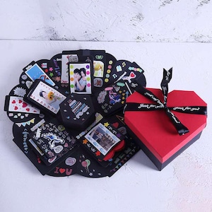 May include: A black and red explosion box with a heart-shaped lid. The box is decorated with photos, stickers, and the words "Just for you".
