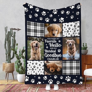 May include: A blue and white fleece blanket with a paw print pattern. The blanket features four photos of golden retrievers and the text "You were my favorite Hello and my hardest Goodbye Charlie".