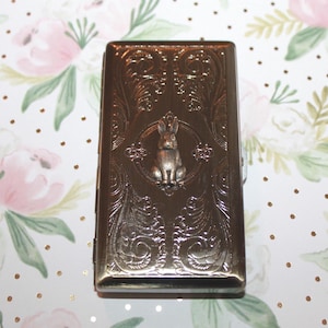 Pitillera, tee de golf y tarjetero de estilo victoriano con el conejo grabado, correspondiente a un año del conejo: 1939, 1951, 1963, 1975, 1987 o 1999.