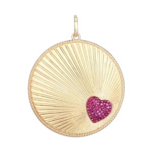 May include: Gold pendant with a textured sunburst pattern. A heart-shaped cluster of pink gemstones is set in the centre. The pendant has a loop at the top for a chain. A stylish piece of jewellery.