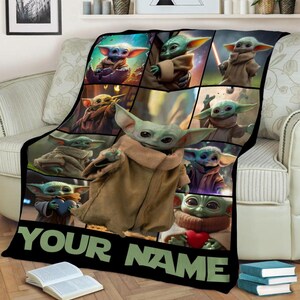 May include: Black blanket featuring multiple images of a green alien character with large ears and brown robes. The blanket has the text "YOUR NAME" in green letters at the bottom.