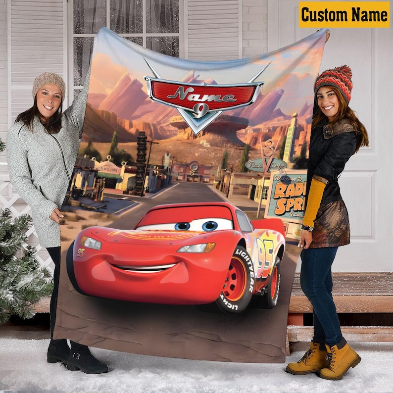 May include: A red Cars-themed blanket featuring Lightning McQueen on a desert road with the text "Name 9" and "Radiator Springs". The blanket has a custom name banner in the top right corner.