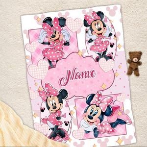 May include: A rectangular blanket featuring a pink and white theme with four distinct illustrations of Minnie Mouse wearing a polka dot dress and bow. The center contains a cloud-shaped graphic with the word Name in a cursive script font.