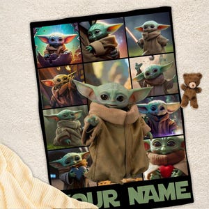 May include: A black blanket featuring multiple images of a green alien character with large ears and a brown robe. A small brown teddy bear is on the right side of the blanket. The text "YOUR NAME" is at the bottom.