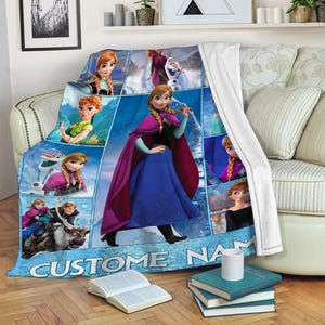 May include: A blue fleece throw blanket featuring images of a princess in a blue dress and a purple cape. The blanket has a collage design with the text "CUSTOM NAME" at the bottom.